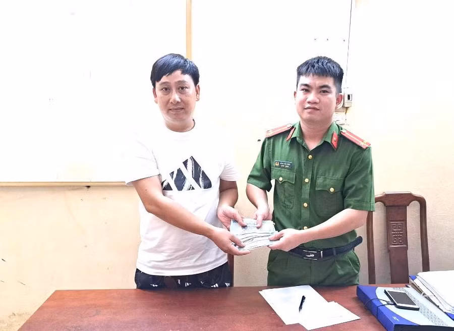 Anh Dũng bàn giao số tiền nhặt trên đường cho Công an huyện Sơn Dương.