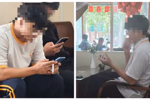 Học sinh mặc đồng phục hút thuốc lá tại một quán cà phê trước cổng trường học. (Ảnh: Thế Hùng)
