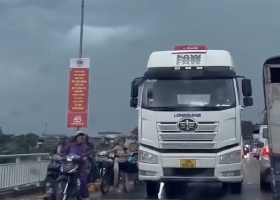 Ô tô che chắn cho các xe máy qua cầu trong mưa dông, gió lớn tại Tuyên Quang.