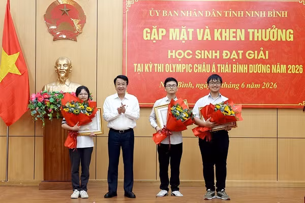 Chủ tịch UBND tỉnh Ninh Bình trao bằng khen và tặng hoa chúc mừng các em học sinh.