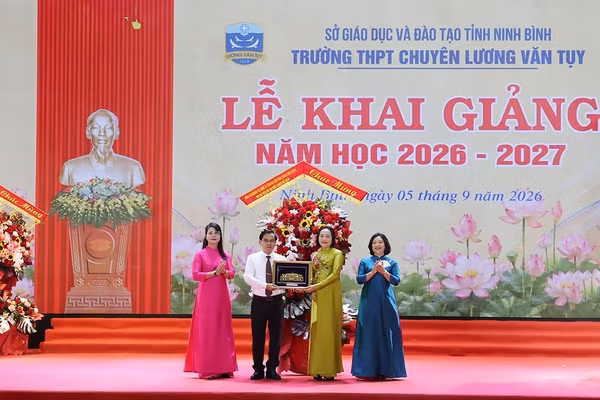 Phó Chủ tịch Quốc hội Nguyễn Thị Thanh tặng hoa và quà lưu niệm là bức tranh Tòa nhà Quốc hội cho Trường THPT chuyên Lương Văn Tụy. Ảnh: Minh Quang