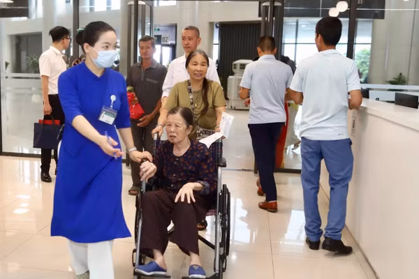 Nhân viên y tế hỗ trợ người dân đến khám, chữa bệnh tại Bệnh viện Bạch Mai cơ sở Ninh Bình trong ngày đầu bệnh viện đi vào hoạt động.
