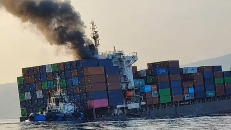 Khói bốc lên từ con tàu container GFS Pride bị cháy đang nghiêng, sau khi va phải thủy lôi ở eo biển Hormuz, ngày 14/10/2026. 