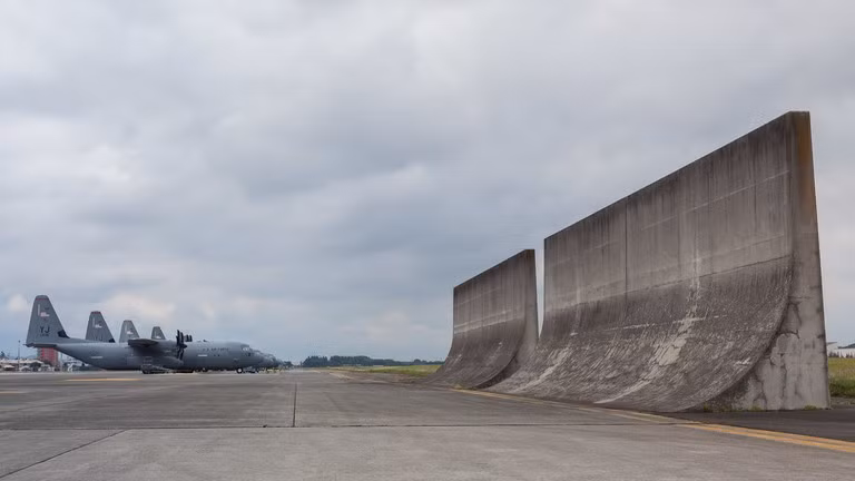 Máy bay Lockheed Martin C130-J Hercules của Mỹ phía sau các tấm chắn luồng khí phản lực tại căn cứ Yokota ở Fussa, Nhật Bản.