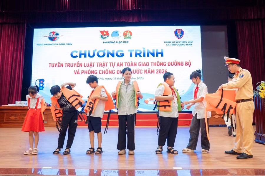 Hướng dẫn học sinh mặc áo phao đúng quy định.