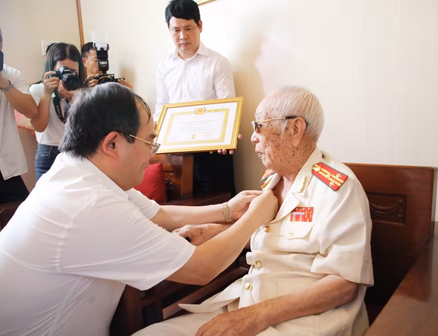 Ông Quản Minh Cường, Bí thư Tỉnh ủy Quảng Ninh trao Huy hiệu 80 năm tuổi Đảng cho cụ Vũ Đức Kính.
