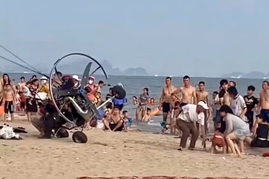 Sau khi húc vào du khách trên bãi biển, dù lượn gắn động cơ bị lật nghiêng. Ảnh cắt từ clip