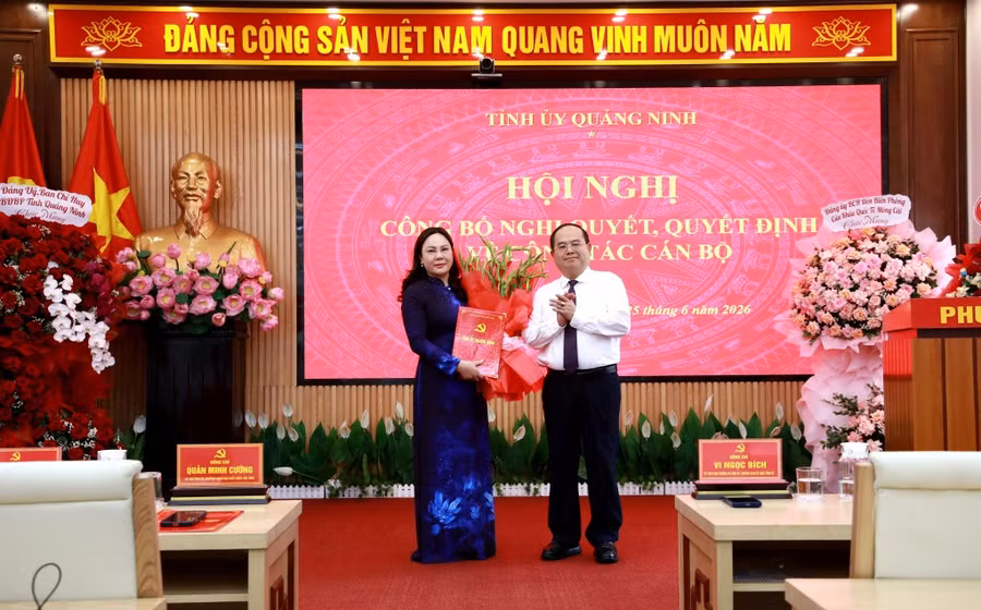 Ông Quản Minh Cường, Bí thư Tỉnh ủy Quảng Ninh trao quyết định, tặng hoa chúc mừng bà Nguyễn Thị Hiền, Bí thư Đảng ủy phường Móng Cái 1.