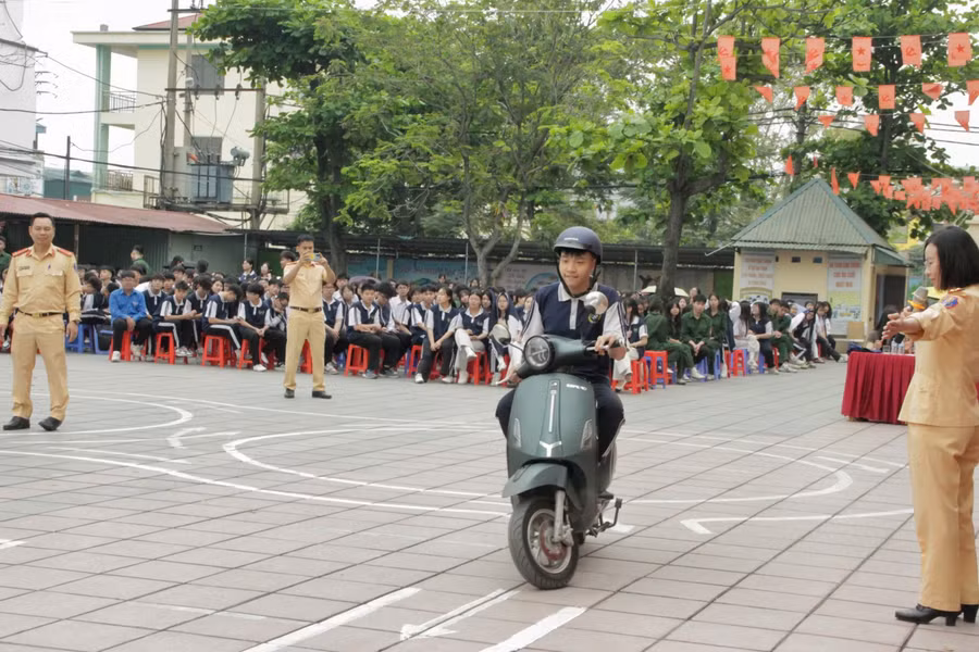 CSGT hướng dẫn học sinh thực hành kỹ năng lái xe gắn máy an toàn.