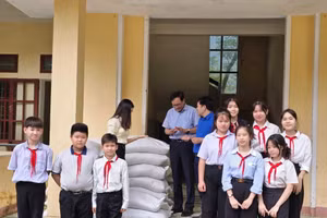 Các em học sinh hân hoan đón nhận gạo trong những ngày đầu năm học mới.