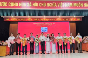 Bà Lê Thị Hương, Giám đốc Sở GD&ĐT và ông Võ Văn Minh, Phó Giám đốc Sở GD&ĐT trao quyết định và chúc mừng 10 Hiệu trưởng sau sắp xếp.