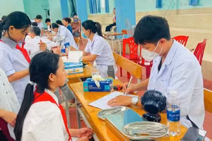 Cán bộ y tế cơ sở khám sức khoẻ cho học sinh.