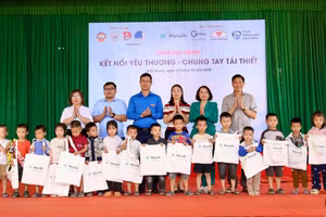Đại biểu trao quà cho học sinh xã Tân Lập.