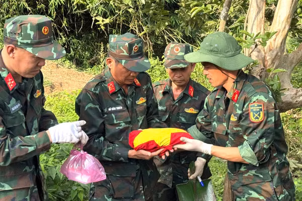 Hài cốt liệt sĩ Y Chông Triêk được các cán bộ, chiến sĩ nâng niu trong màu cờ đỏ sao vàng.