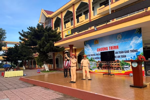 Cán bộ Phòng CSGT giới thiệu kiến thức về Luật Trật tự, an toàn giao thông đường bộ cho học sinh. (Ảnh: NTCC)