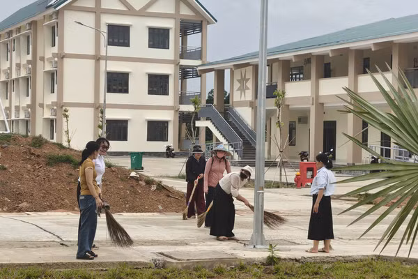 Thầy cô tất bật dọn vệ sinh sân trường. (Ảnh: T.H)