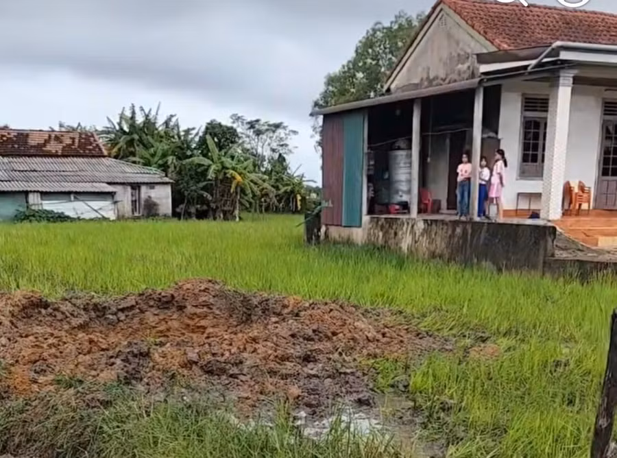Hố sâu giữa ruộng sau vụ nổ lớn, nghi do bom sót lại.