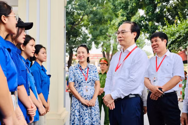 Bộ trưởng Hoàng Minh Sơn trò chuyện với thanh niên tình nguyện hỗ trợ tại điểm thi Trường THPT Kim Động, tỉnh Hưng Yên.