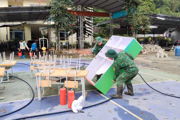 Lực lượng chức năng hỗ trợ khắc phục hậu quả thiên tai tại Trường Mầm non và Trường Tiểu học Minh Long.