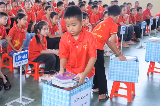 Học sinh Trường Tiểu học Nghi Văn (xã Nghi Văn, Nghệ An) quyên góp sách tặng cho bạn học khó khăn và tủ sách dùng chung. Ảnh: Hồ Lài