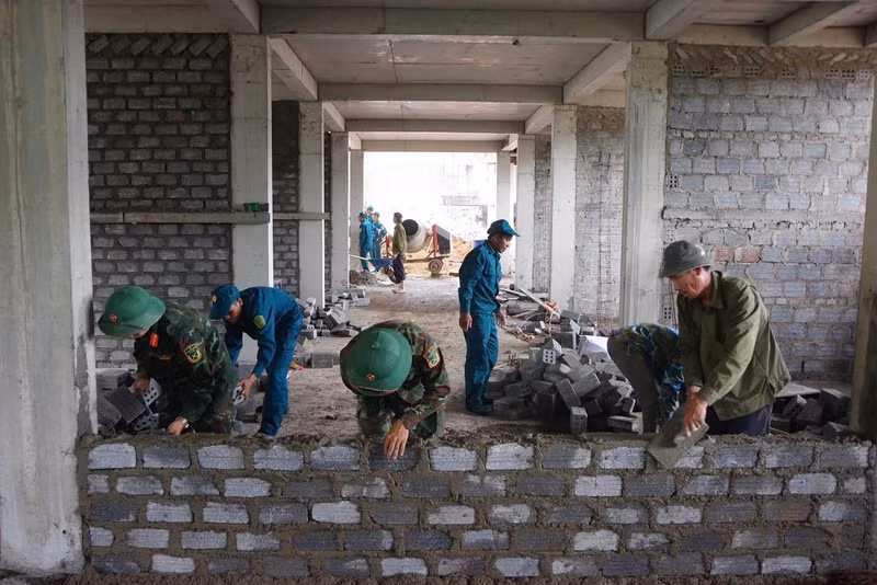 Tại các công trình, lực lượng quân sự phối hợp với đơn vị thi công triển khai nhiều phần việc như san gạt mặt bằng, vận chuyển vật liệu, đào đắp nền móng và hỗ trợ xây dựng các hạng mục. bo-doi-4.jpg