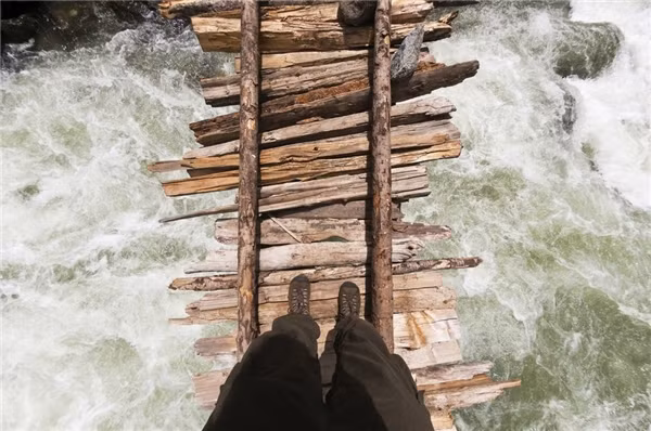 Một phượt thủ băng qua cây cầu gỗ bắc ngang sông Kanka thuộc Naranag, khu vực Hồ Gangabal, Kashmir Himalayas, Ấn Độ.&nbsp;