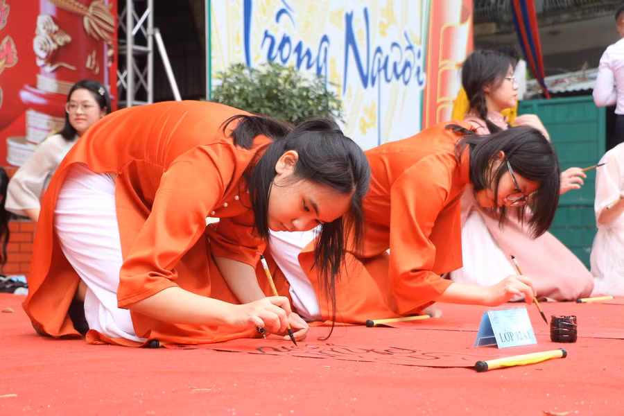 Các em tham gia thi Viết chữ thư pháp.