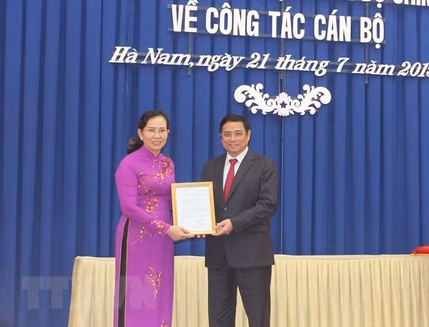 Ông Phạm Minh Chính, ủy viên Bộ Chính trị, Bí thư Trung ương Đảng, Trưởng ban Tổ chức Trung ương trao quyết định của Bộ Chính trị cho bà Lê Thị Thủy. Ảnh: TTXVN
