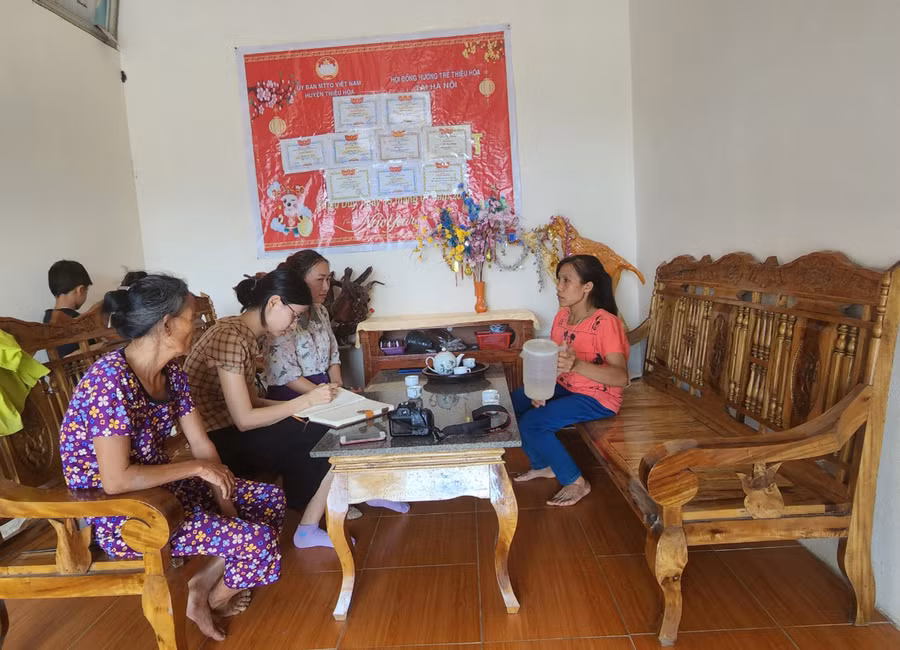 Bà Nga (áo tím - bìa trái) cùng con dâu (áo đỏ) trò chuyện cùng cán bộ chính sách xã Thiệu Duy, Thiệu Hóa (Thanh Hóa) trong căn nhà mới khang trang.