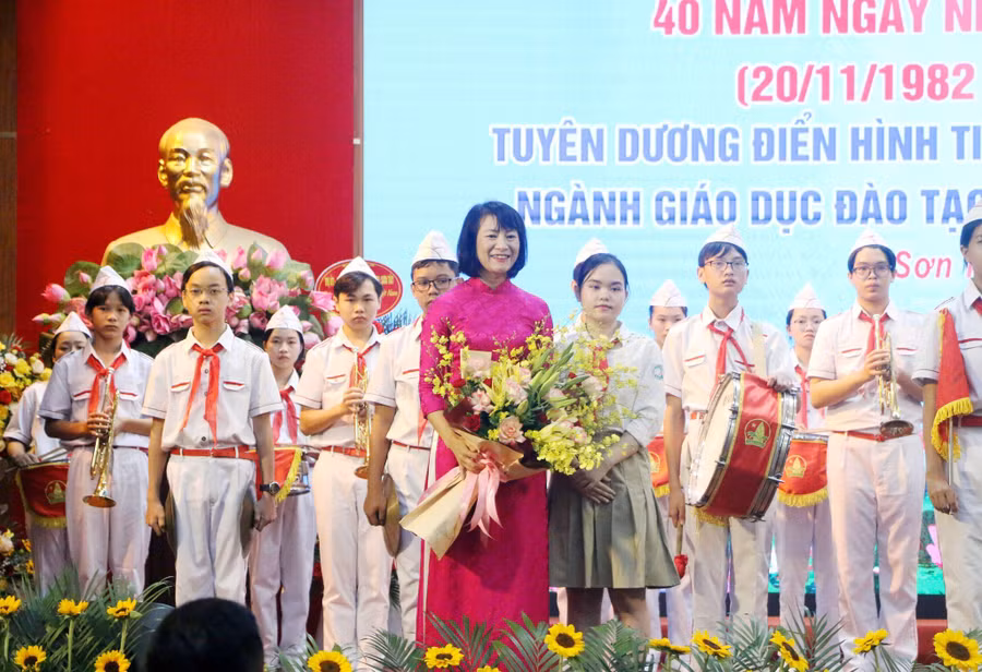 Nhà giáo Phan Thị Thu Hương - Thị ủy viên, Trưởng Phòng GD&amp;ĐT thị xã Sơn Tây tiếp nhận bó hoa tươi thắm từ các em học sinh tại buổi lễ.