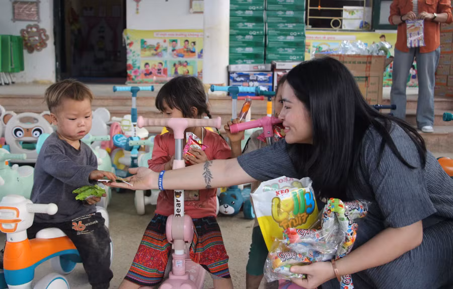 Chị Hoàng Thị Hoa tặng bánh kẹo cho học sinh điểm trường Pú Vang.