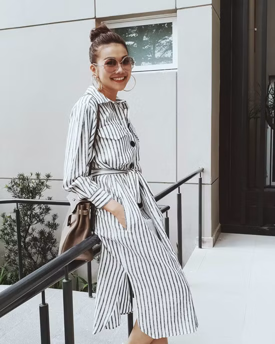 Khi chọn váy kẻ sọc kiểu vintage, Thanh Hằng giúp mình có được nét hài hòa bởi cách tạo kiểu toc oca cùng hoa tai to bản theo đúng phong cách cổ điển.