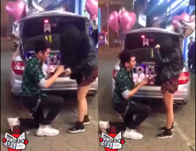 Chàng trai quỳ gối cầu hôn cô gái ngay trên phố. Ảnh cắt từ clip.