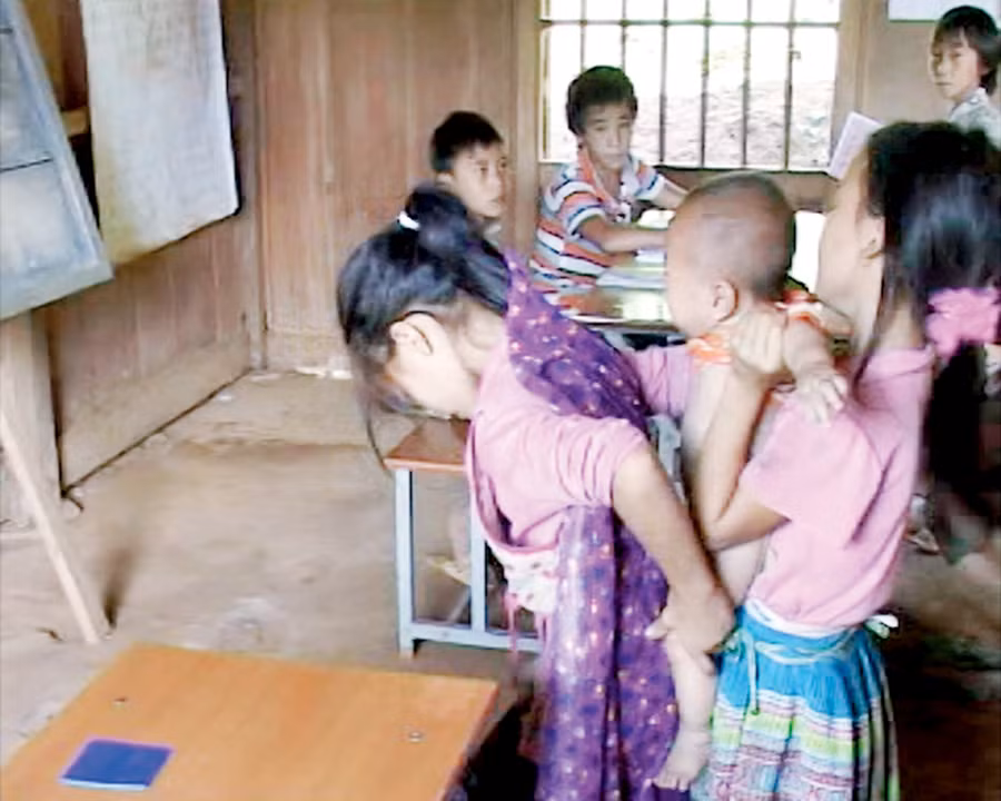 Hỗ trợ bạn thay đồ cho em trên lớp học Hỗ trợ bạn thay đồ cho em trên lớp học