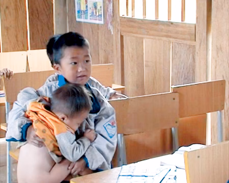 HS tiểu học vừa ru em ngủ vừa học bài HS tiểu học vừa ru em ngủ vừa học bài