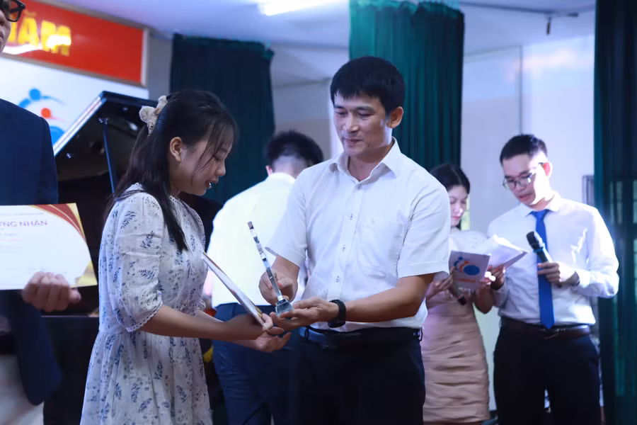 Thầy Hiệu trưởng Nguyễn Quang Tùng trao giải Nhất cho nữ sinh Đào Ban Mai đến từ lớp 11E.