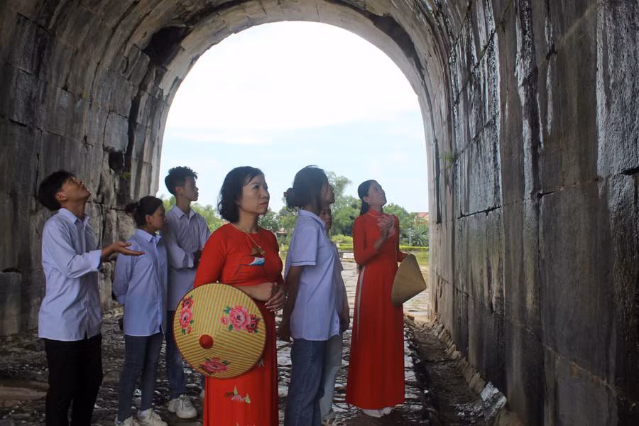 Cô Quách Lan Anh cùng học sinh lớp 12A7 tham quan, tìm hiểu về cổng thành phía Nam, Thành nhà Hồ. Ảnh: LT.