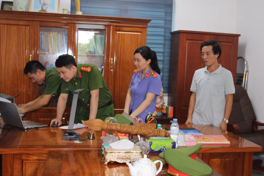 Khám xét nơi làm việc của Trưởng phòng Tư pháp, nguyên Trưởng phòng Tài chính thị xã Cửa Lò. Ảnh: CANA.
