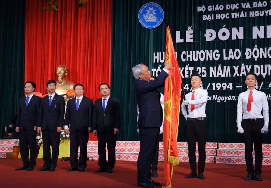 Phó Chủ tịch Quốc hội Uông Chu Lưu gắn Huân chương Lao động hạng Nhất lên lá cờ truyền thống của ĐH Thái Nguyên