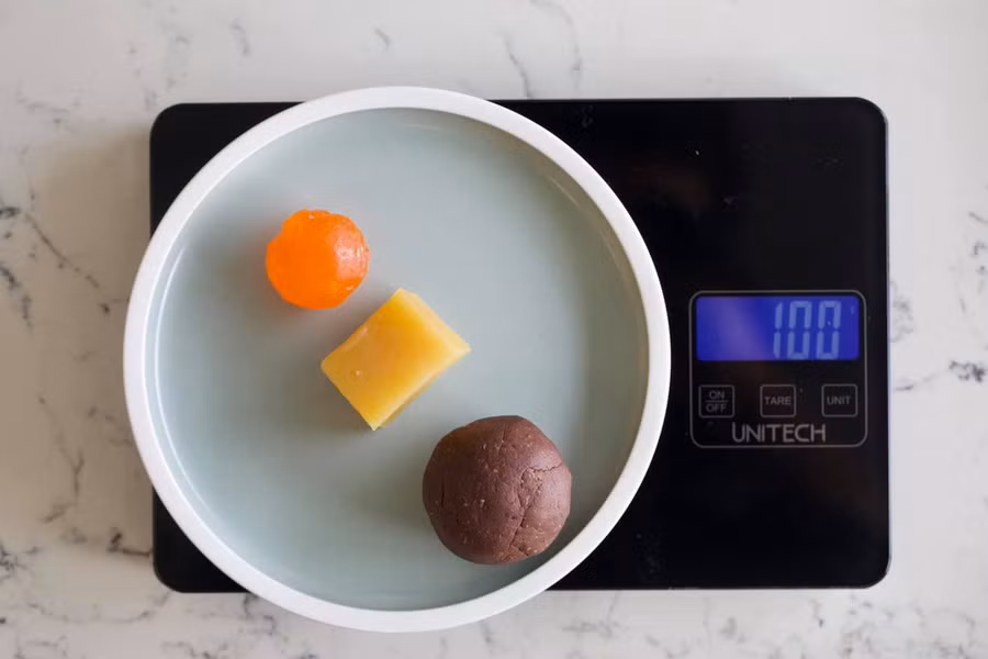 Cân nguyên liệu cho bánh cỡ 100g.