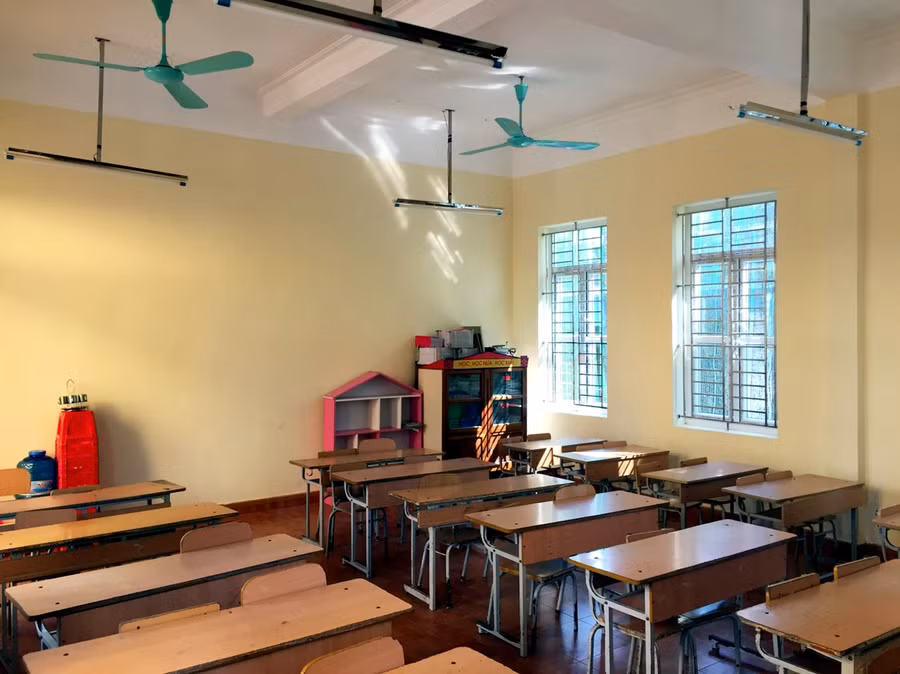 Phòng học được trang bị quạt, đèn chiếu sáng cùng bàn ghế, bảng viết...