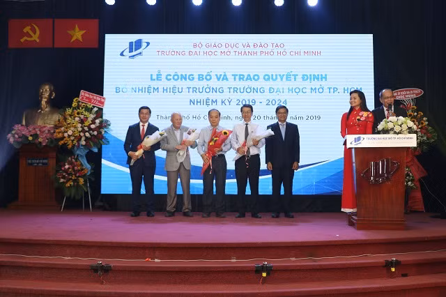 Tân hiệu trưởng ĐH Mở TPHCM Nguyễn Minh Hà (bìa phải) tặng hoa cảm ớn các thế hệ hiệu trưởng trước của nhà trường, cũng như sự quan tâm tâm chỉ đạo của Thứ trưởng Nguyễn Văn Phúc