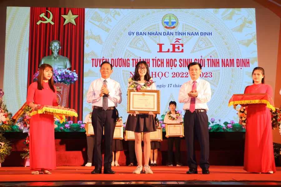 Chủ tịch UBND tỉnh Nam Định Phạm Đình Nghị (phải) và ông Nguyễn Phùng Hoan (trái) - Phó Chủ tịch HĐND tỉnh Nam Định tặng Bằng khen của UBND cho các em học sinh xuất sắc.