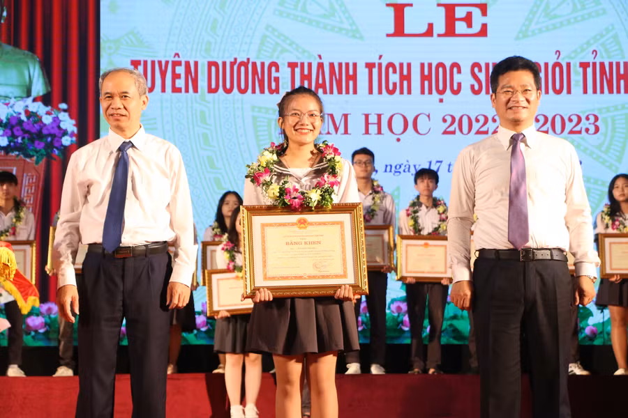 Phó Chủ tịch UBND tỉnh Nam Định Trần Anh Dũng (phải) và Chủ tịch MTTQ tỉnh Nam Định Đặng Xuân Hùng (trái) tặng Bằng khen cho các em học sinh tiêu biểu.