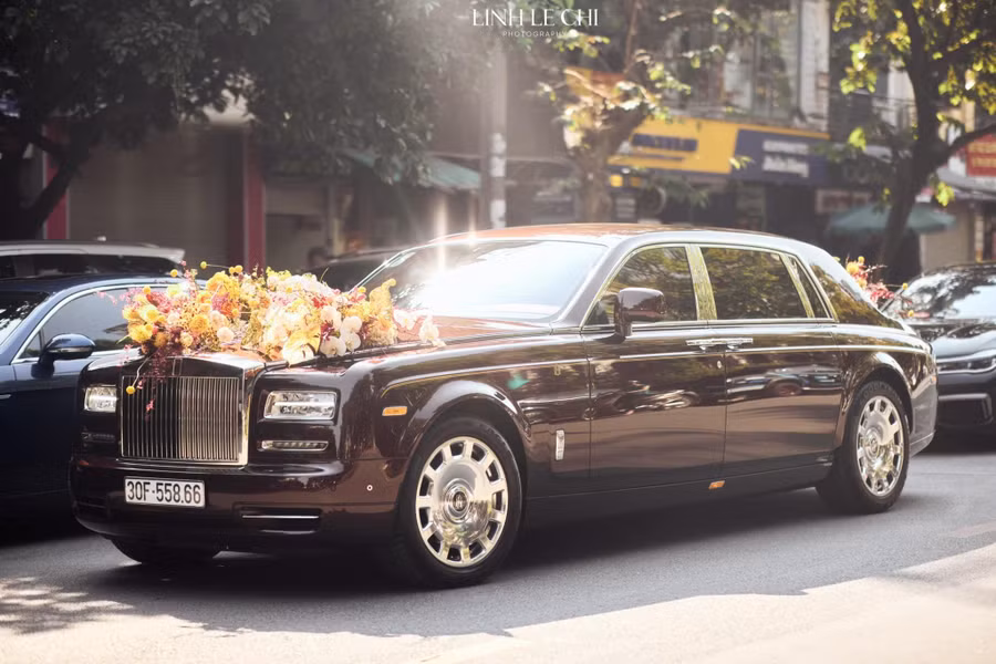 Nhà trai rước dâu bằng xế hộp Rolls-Royce Phantom. Đây chính là chiếc Rolls-Royce Phantom "Hòa bình Vinh quang" thuộc sở hữu của đại gia Đỗ Quang Hiển (hay còn được gọi là bầu Hiển), là bố chú rể. Được biết, thời điểm chiếc xe được nhập khẩu về có giá lên đến 83 tỷ đồng, trở thành chiếc Phantom đắt nhất Việt Nam. Ảnh: Linh Le Chi.