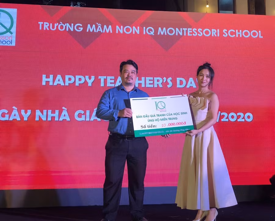 Cô Dương Thị Hoài Hương - Giám đốc điều hành hệ thống Trường mầm non IQ trao số tiền 10 triệu đồng đấu giá tranh cho đại diện Báo Giáo dục và Thời đại để mua sách vở ủng hộ các em học sinh miền Trung