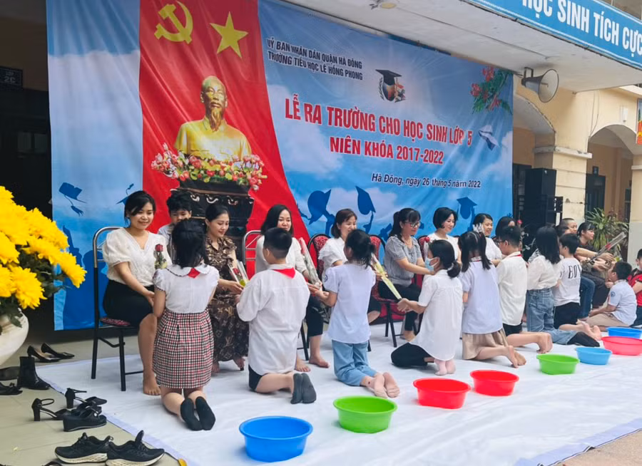 Học sinh khối 5 lên tặng hoa để tri ân bố mẹ đã có công sinh thành, dưỡng dục mình.
