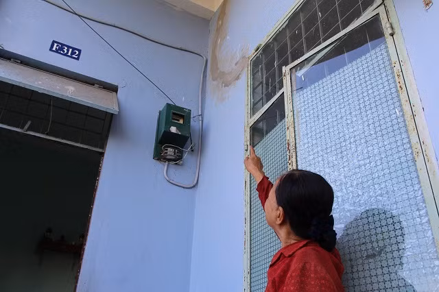 Bà Hà Thị Ái ngán ngẩm chỉ lên vết nứt mà gia đình vừa mua xi măng khắc phục.