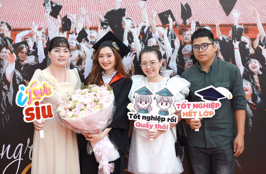Một tân cử nhân bên cạnh người thân của mình trong ngày vui tốt nghiệp.