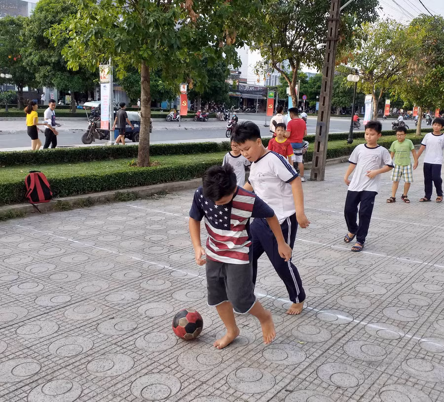 Trẻ em vô tư đá bóng ven đường Trẻ em vô tư đá bóng ven đường